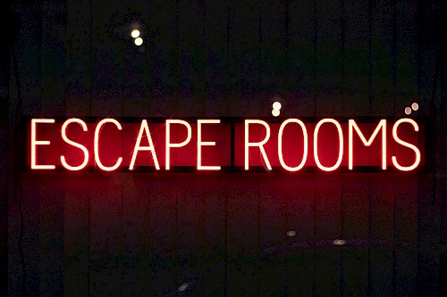 Neonschild in Rot mit dem Schriftzug Escape Rooms