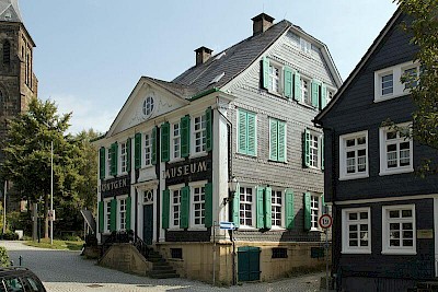 Historisches Haupthaus des Deutsches Röntgen Museums mit grüner Holzfassade.